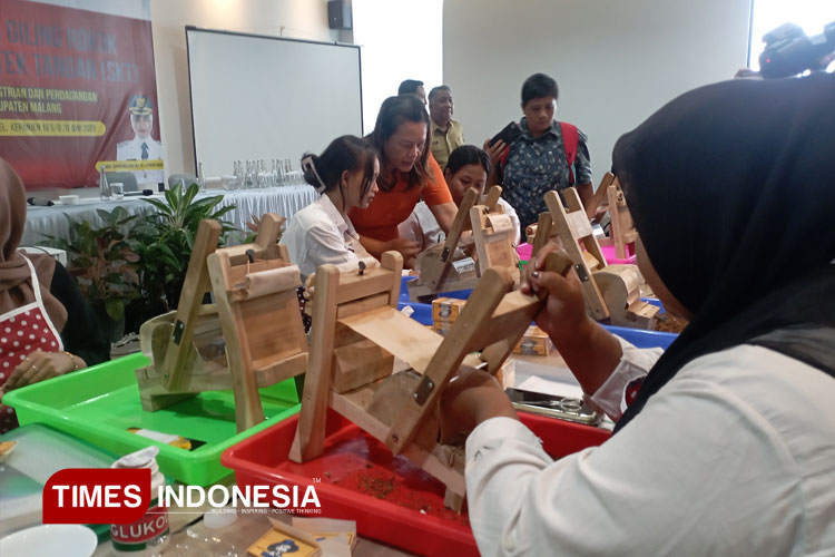 Peserta Pelatihan Giling SKT tampak serius menggiling rokok secara manual dengan alat linting, dalam pelatihan yang difasilitasi dari DBHCHT oleh Disperindag Kabupaten Malang, Senin (16/6/2025). (Foto: Amin/TIMES Indonesia)