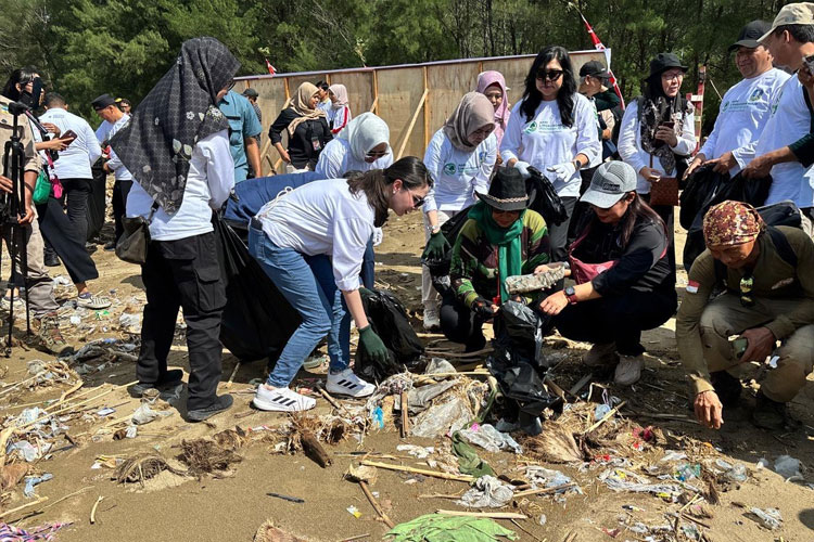 Ketua Tim Penggerak PKK Jatim Arumi Bachsin bersama relawan saat membersihkan sampah di Pantai Gemah, Tulungagung, Kamis (5/6/2025).(Dok.PKK Jatim)