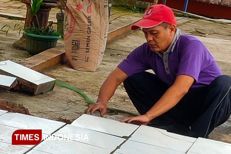 Dedikasi Tanpa Batas, Kepala SMAN Tulakan Pacitan Bantu Pasang Keramik
