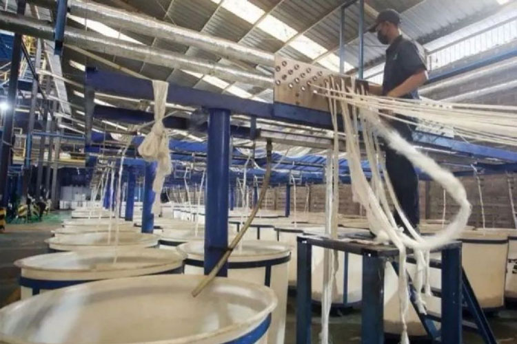 Ilustrasi - Pekerja melakukan proses penarikan benang filamen dari olahan limbah botol plastik bekas. (FOTO: ANTARA FOTO/Muhammad Iqbal)
