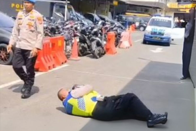 Foto tangkapan layar Aiptu Rudi Hartono, personel Satuan Lalu Lintas (Satlantas) Polrestabes Medan menjalani hukuman fisik berguling-guling di aspal.
