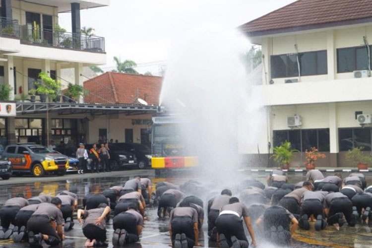 Sebelum upacara, personel yang naik pangkat disiram air. (FOTO: Humas Polresta) Foto 2-3: Peserta upacara mendengarkan amanah Kapolresta Cilacap. (FOTO: Humas Polresta Cilacap for TIMES Indonesia)