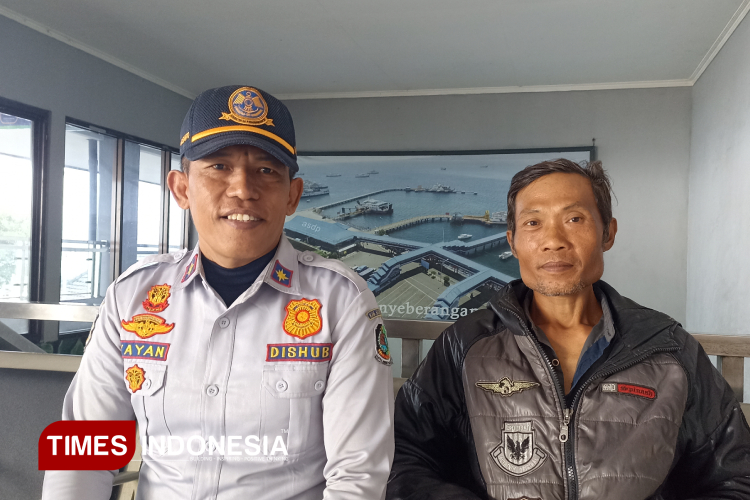Rois (kiri) ditemani petugas Dishub Banyuwangi, sedang menunggu kabar keluarganya yang menjadi korban KMP Tunu Pratama Jaya. (FOTO: Ikromil Aufa/TIMES Indonesia)