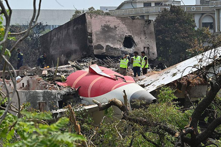 Petugas saat melakukan identifikasi puing-puing pesawat Boeing 787 milik Air India yang jatuh sesaat setelah take off dari Bandara Ahmedabad.