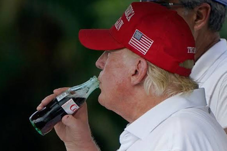 Presiden AS Donald Trump saat minum Coca-Cola dalam sebuah acara golf. Donald Trump meminta Coca-Cola memakai gula tebu untuk pemanis.