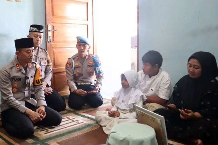 Kapolres Garut AKBP Yugi Bayu Hendarto saat menyerahkan SK Kenaikan Pangkat Anumerta Alm Aipda Cecep Saepul Bahri kepala keluarga di rumah duka, Kabupaten Garut, Jawa Barat, Sabtu (19/7/2025). (ANTARA/HO-Polres Garut)