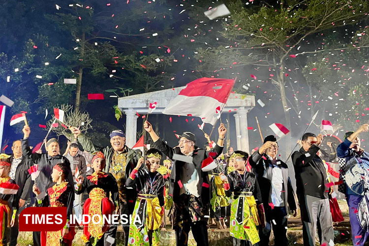 Hadirin dan seniman mengibarkan bendera Merah Putih dalam kemeriahan Festival Kopi Perdamaian de Karanganjar di Blitar. (FOTO: Ardana Pramayoga/TIMES Indonesia)