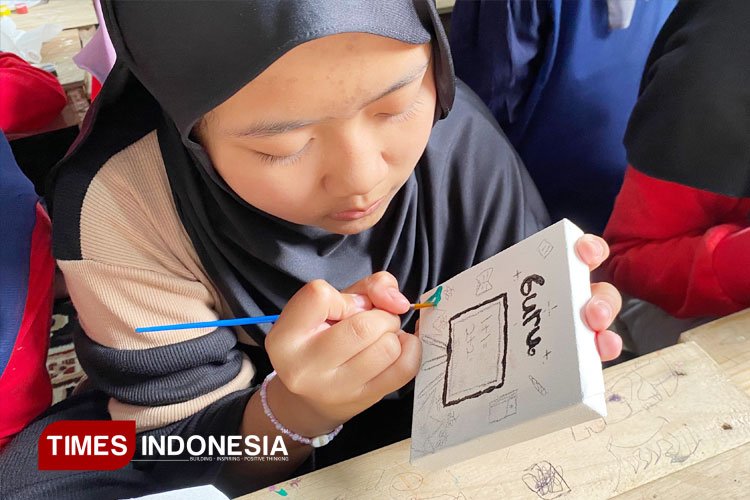 Seorang anak sedang fokus melukis di atas Canvas, dia mengekspresikan cita-citanya dengan penuh semangat.  (Foto: Afanin Rushafah/TIMES Indonesia)