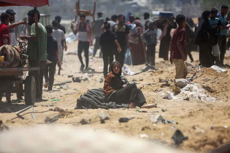 Foto bertanggal 11 Juli 2025 memperlihatkan seorang perempuan Palestina duduk di antara puing dan kerumunan pengungsi di Jalur Gaza. (FOTO: AFP)