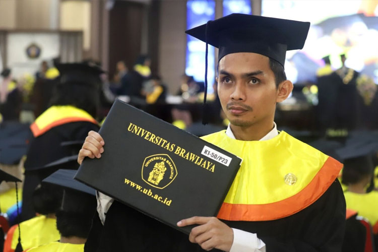 Andi Zulfajrin Syam, mahasiswa difabel netra dari Departemen Hubungan Internasional FISIP UB yang diwisuda pada Sabtu (19/7/2025). (FOTO: Humas UB)