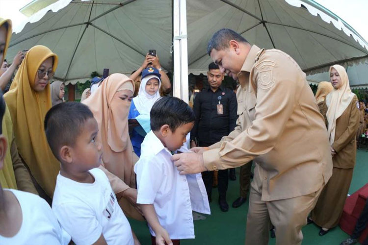 Wali Kota Makassar Munafri Arifuddin saat memakaikan baju seragam sekolah kepada beberapa orang murid SD di Makassar sebagai tanda dimulainya pembagian seragam sekolah gratis di Makassar, Senin (21/7/2025). (FOTO: ANTARA/HO-Dokumen pribadi)