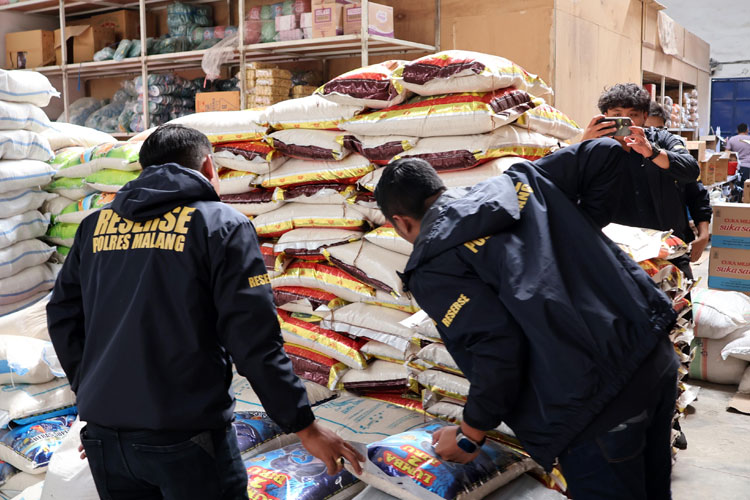 Petugas Satgas Pangan saat memeriksa beras kemasan di salah satu gudang distributor bahan pokok di wilayah Kabupaten Malang, Selasa (22/7/2025). (Foto: Polres Malang)