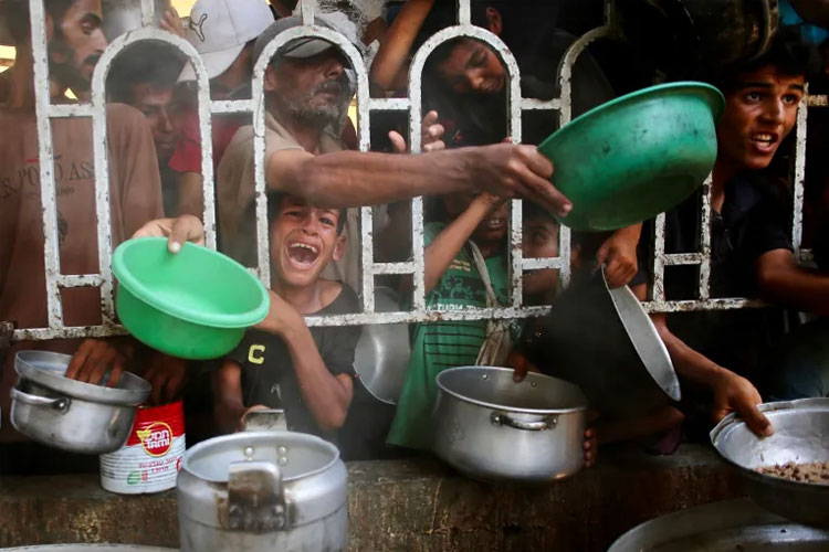 Warga Palestina termasuk anak-anak berkumpul untuk menerima makanan di dapur amal di daerah al-Mawasi, Khan Younis, Gaza selatan. (foto: AFP/Aljazerra)