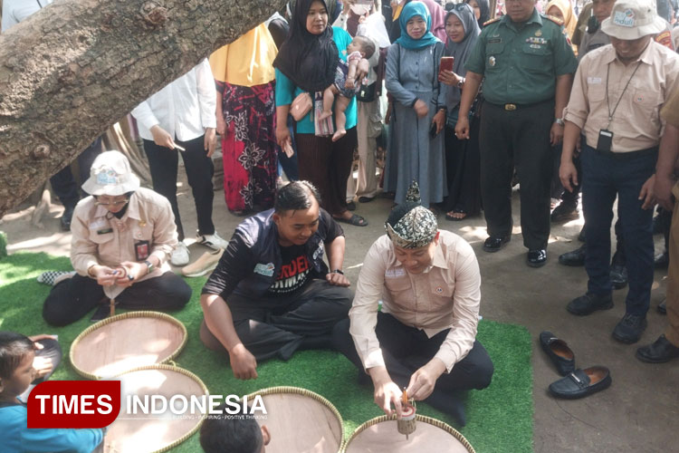 Bupati Sidoarjo Subandi mencoba permainan tradisional dalam perayaan Hari Anak Nasional di Kampung Lali Gadget. (FOTO: Syaiful Bahri/TIMES Indonesia)