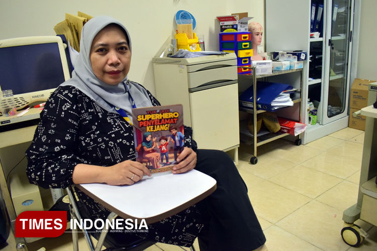 Dr. dr Wardah R. Islamiyah Sp.N (K) menunjukkan buku karyanya edukasi epilepsi berjudul Yuk Jadi Super Hero Penyelamat Kejang, Senin (28/7/2025). (Foto: Hamida Soetadji/TIMES Indonesia)