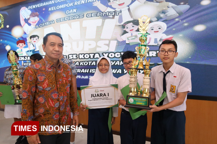 Kepala Kejati DIY, Riono Budisantoso ketika menyerahkan trofi dan hadiah kepada pemenang juara 1 lomba cerdas cermat. (FOTO: Riyadi/TIMES Indonesia)