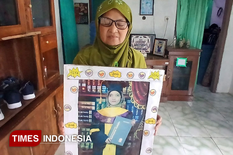 Yati menunjukan foto anaknya, SW, yang kini tertahan di Brunei Darussalam sebagai PMI non prosedural. (Foto: Susi/Times Indonesia)