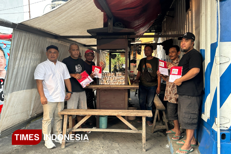 Ketua DPC Partai Gerindra Sleman membagikan bendera putih kepada pedagang, pengungjung angkringan, dan pengguna jalan. (FOTO: Riyadi/TIMES Indonesia)