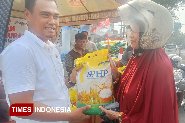 KBO Reskrim Polres Pemalang Iptu Dwi Hermono secara simbolis menyerahkan beras murah yang dibeli warga dalam kegiatan Gerakan Pangan Murah di depan Pos Polisi Alun-alun Pemalang, Rabu (13/8/2025).(Foto: Ragil/TIMES Indonesia)