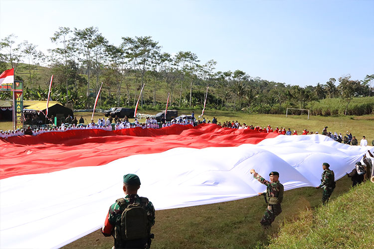 Yonarmed 12 Kostrad dan Warga Bentangkan Bendera Raksasa di Harjokuncaran Malang