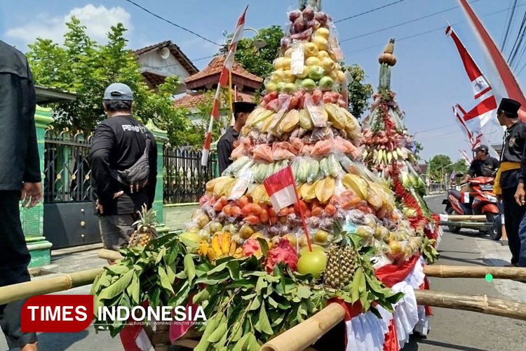 Tumpeng agung berisi aneka sayur mayur dan hasil bumi diarak keliling kampung menyertai tradisi bersih desa di Jiwan, Madiun. (Foto: Yupi Apridayani/TIMESIndonesia)