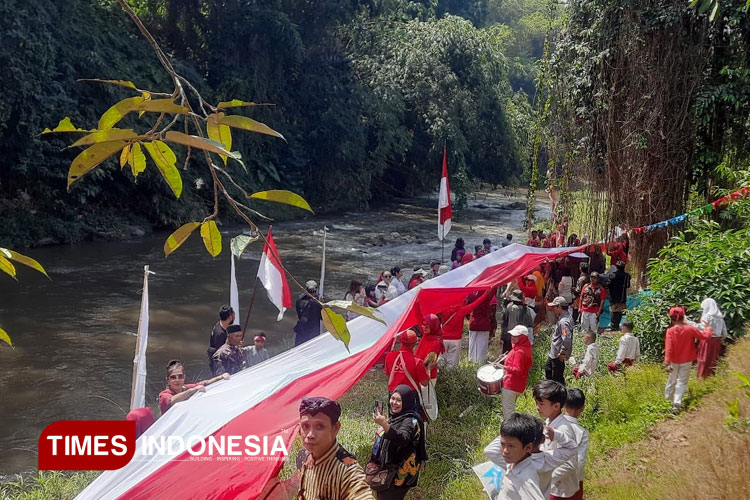 Momen ratusan warga bawa bendera merah putih sepanjang 80 meter di sepanjang sungai brantas, Kota Malang. (Foto: Rizky Kurniawan Pratama/TIMES Indonesia)