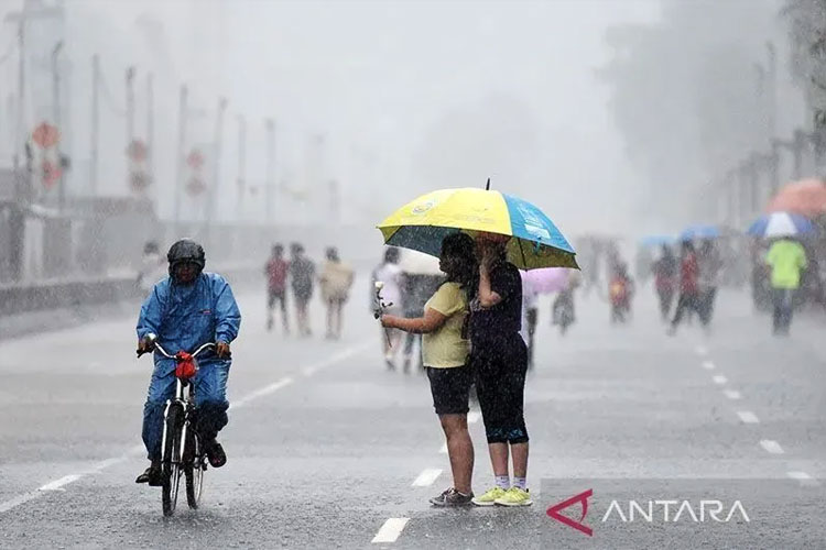 Warga menggunakan payung di tengah hujan deras di kawasan MH Thamrin Jakarta. (FOTO: Antara)