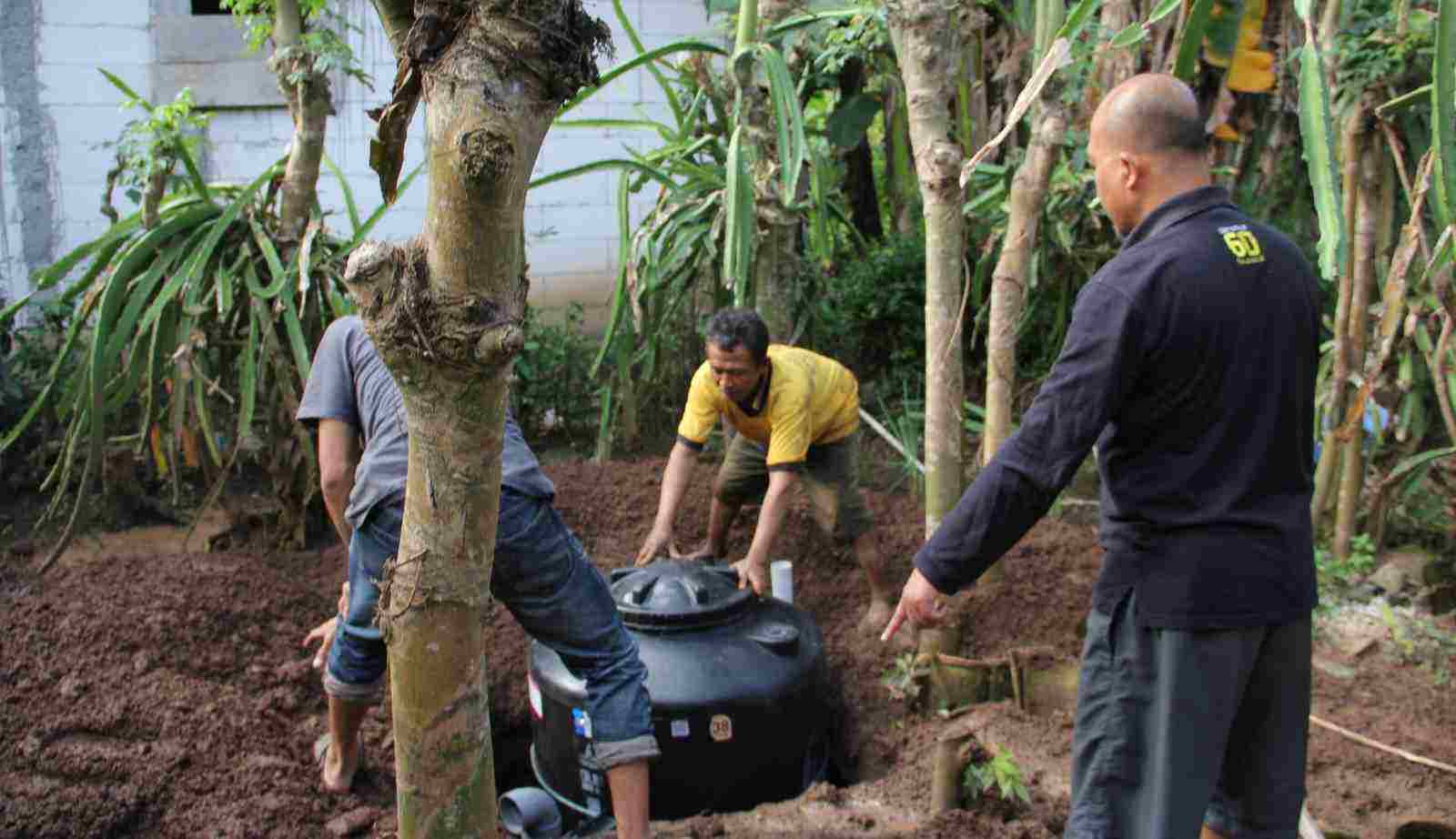 Pemasangan tabung untuk menampung kotoran kambing penghasil energi gas untuk kompor warga. (Foto: Dep Kimia UB)