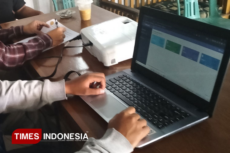 Seorang mahasiswa Unper saat memperlihatkan program aplikasi Simanisku di salah satu laptop di Aula Desa Dayeuhluhur Ciamis, Kamis (21/8/2025) (FOTO: Harniwan Obech/TIMES Indonesia)