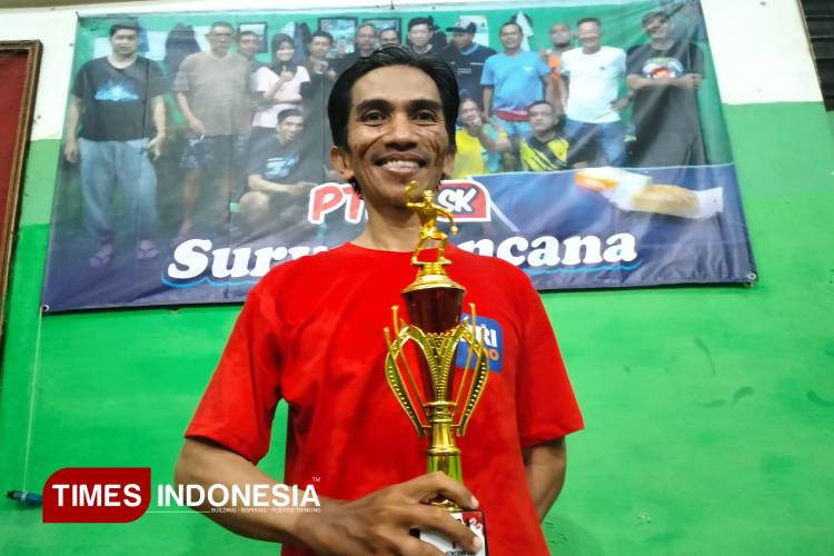 Junjun 'Jun Sae Yuk' menunjukkan piala yang diraihnya pada Kejuaraan PTM Surya Kencana, Minggu (24/8/2025) malam. (FOTO: Harniwan Obech/TIMES Indonesia)