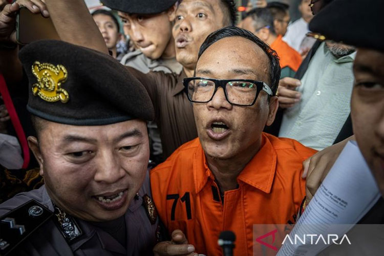 Wakil Menteri Ketenagakerjaan Immanuel Ebenezer (tengah) berjalan menuju mobil tahanan usai dihadirkan sebagai tersangka saat konferensi pers di Gedung Merah Putih KPK, Jakarta, Jumat (22/8/2025).
