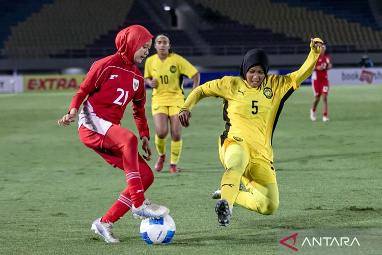 Pesepak bola timnas putri Indonesia Diva Aulia Putri (kiri) berusaha melewati adangan pesepak bola timnas putri Malaysia Ireena Syazreen Binti Muhammad Fuad (kanan) di Grup A Kejuaraan ASEAN Putri U-16 di Stadion Manahan. ANTARA