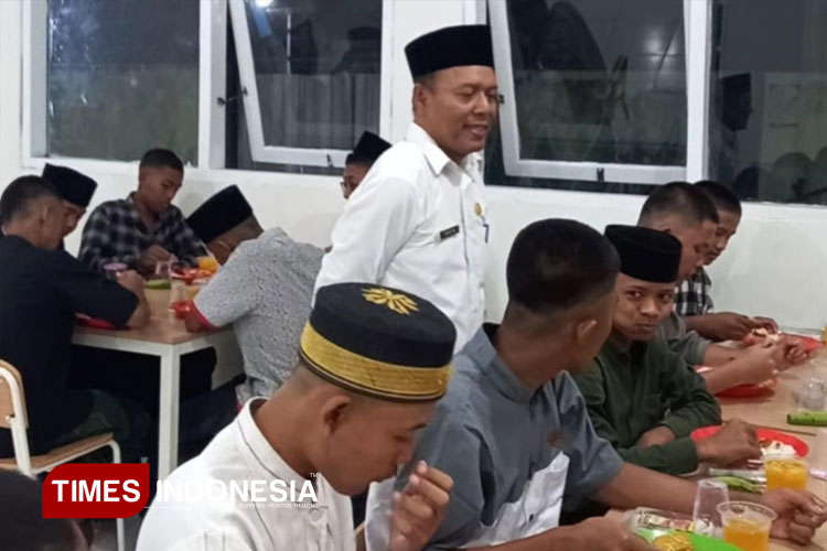 Camat Sidayu Suwartono saat meninjau siswa sekolah rakyat makan malam dengan menu sate. (FOTO: Akmal/TIMES Indonesia).