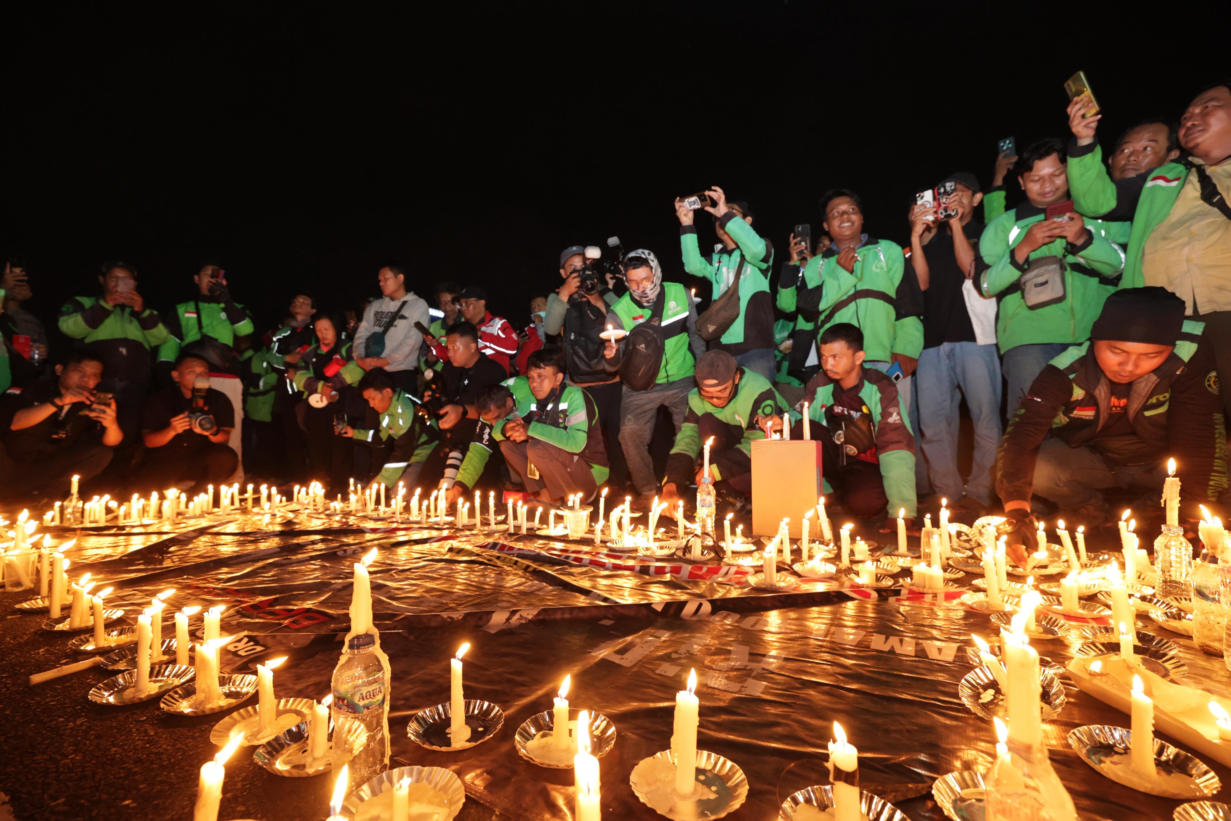 Driver Ojol Doa Bersama Nyalakan Lilin di Halaman Mapolda Jatim