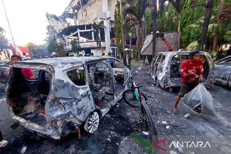 Sejumlah orang membawa barang hasil jarahan usai Kantor DPRD Kota Makassar dibakar massa, di Jalan Andi Pangeran Pettarani, Makassar, Sulawesi Selatan, Sabtu (30/8/2025). (Foto: Antara/Darwin Fatir)