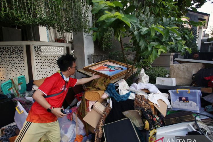 Pekerja mengumpulkan barang yang dikeluarkan dari rumah Menteri Keuangan Sri Mulyani oleh massa tidak dikenal di Bintaro, Tangerang Selatan, Banten, Minggu (31/8/2025). (FOTO: ANTARA FOTO/Muhammad Iqbal/nz)