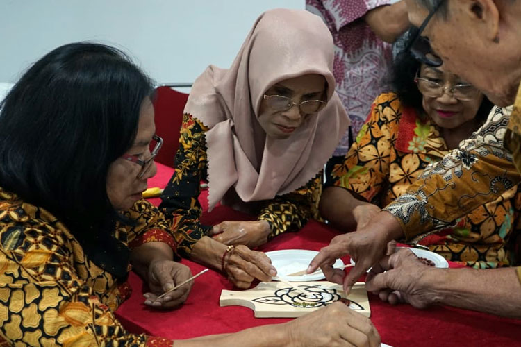 Lansia secara kelompok membuat mozaik biji-bijian yang menjadi bagian kegiatan Pengembangan Relasi Positif untuk Meningkatkan Keyakinan Diri Kader dan Kesehatan Lansia yang digelar PPKG LPPM UNS bersama RS Panti Waluyo Surakarta. (Foto:PPKG LPPM UNS)