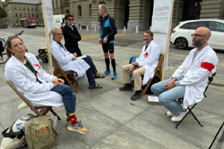 Tampak Dokter Michele Ghielmini, Brenno Balestra, Alessandra Guaita, dan Marco Franzi duduk di luar gedung Parlemen Swiss (Bundeshaus) pada awal aksi mogok makan mereka untuk Gaza.(FOTO: Reuters)