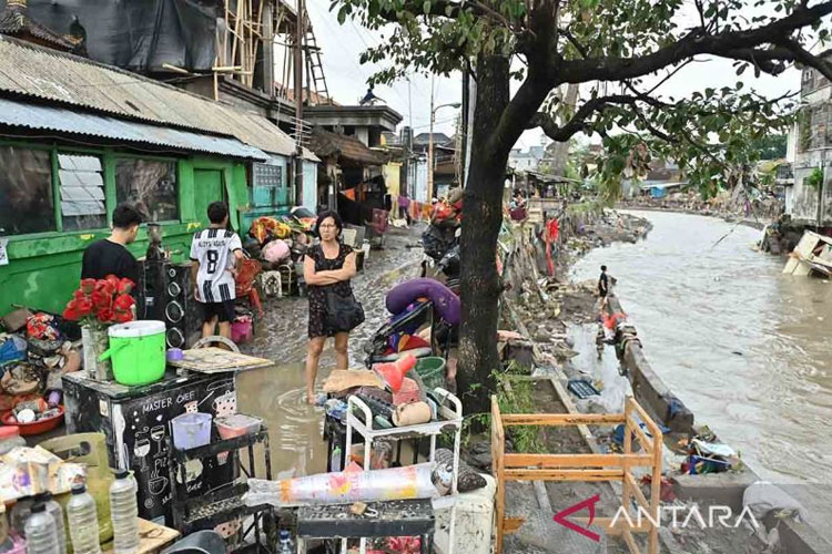 Warga berjalan di dekat bangunan rumah terdampak banjir di kawasan Jalan Bukit Barisan, Denpasar, Bali, Rabu (10/9/2025). (ANTARA FOTO/Fikri Yusuf)