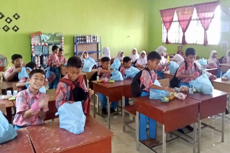 Siswa siswi SD yang sedang menikmati makanan MBG di salah satu sekolah di Kota Batam, Kepri. Selain siswa, MGG juga akan diberikan kepada guru dan relawan posyandu. (ANTARA/HO-SPPG Batam)