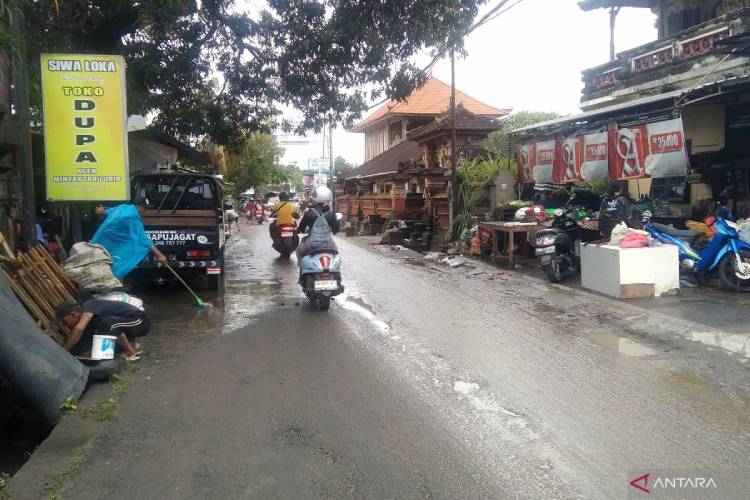 Pelaku usaha membersihkan lumpur setelah tokonya terendam banjir di Jalan Siulan, Denpasar, Bali, Rabu (10/9/2025). (FOTO: ANTARA/Dewa Ketut Sudiarta Wiguna)