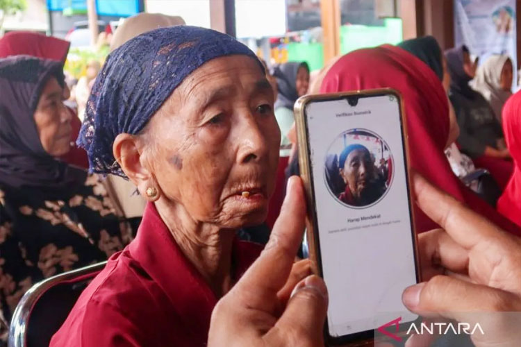 Petugas melakukan verifikasi wajah pada uji coba pendaftaran digitalisasi bantuan sosial di Desa Wisata Adat Osing Kemiren, Banyuwangi, Jawa Timur, Kamis (18/9/2025). Banyuwangi. (FOTO: Antara)