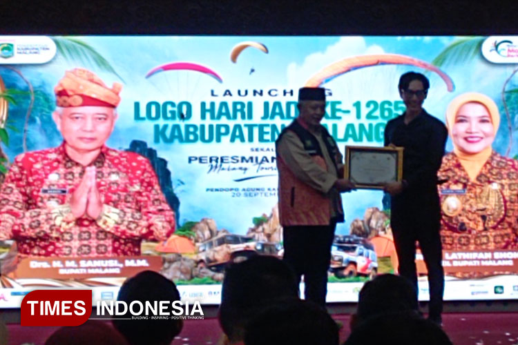 Bupati Malang H. Sanusi memberikan penghargaan pada pembuat logo Hari Jadi ke-1265 Kabupaten Malang usai dilaunching di Pendopo Agung Kabupaten Malang, kemarin. (Foto: Adhitya Hendra/TIMES Indonesia)