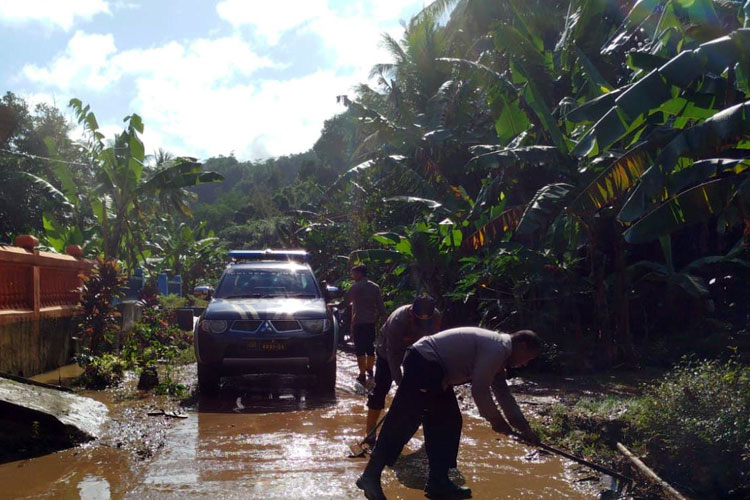 Personel bersama relawan saat membersihkan jalan yang sempat terendam lumpur dan genangan akubat banjir di Desa Sitiarjo Sumbermanjing Wetan Kabupaten Malang kemarin. (Foto: Polres Malang for TIMES Indonesia)