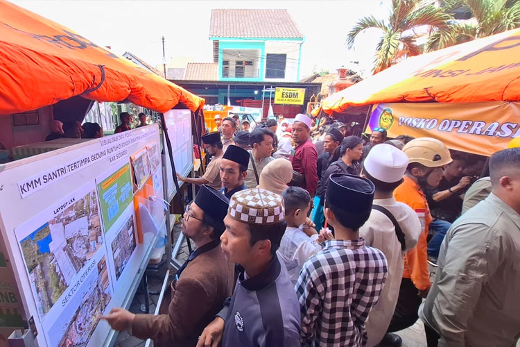 Wali Santri melihat informasi terkait perkembangan proses evakuasi di posko Basarnas. (FOTO: TIMES Indonesia/Syaiful Bahri)