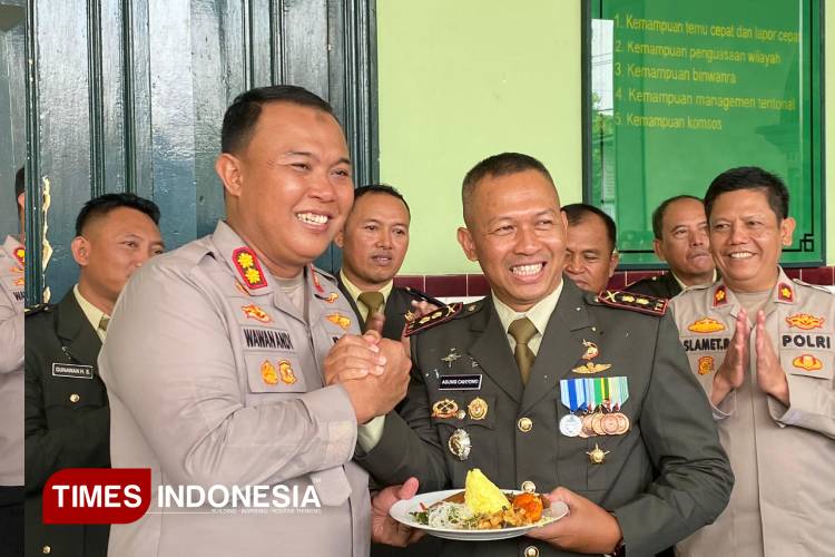 Kapolres Blora AKBP Wawan Andi Susanto memberikan tumpeng kepada Komandang Kodim 0721/Blora  Letkol Inf Agung Cahyono dalam momen HUT ke-80 TNI. (FOTO: Rengga/TIMES Indonesia)