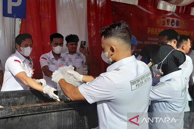 Personel Ditresnarkoba Polda Aceh membuka bungkusan sabu-sabu untuk dimusnahkan dalam cairan mendidik di Banda Aceh, Senin (6/10/2025). (FOTO: ANTARA/M Haris SA)