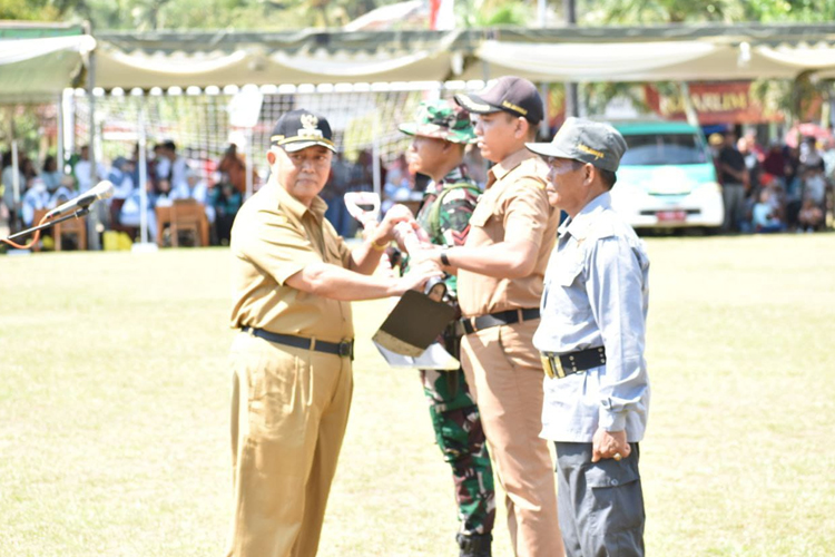 Bupati Malang H. Sanusi menyerahkan peralatan oenunjang kegiatan TNI Manunggal Membangun Desa ke-126 Tahun 2025 Kodim 0818/Malang-Batu, pada upacara pembukaan di Desa Lebakharjo Ampelgading Kabupaten Malang, Rabu (8/10/2025). (Foto: Prokopim)