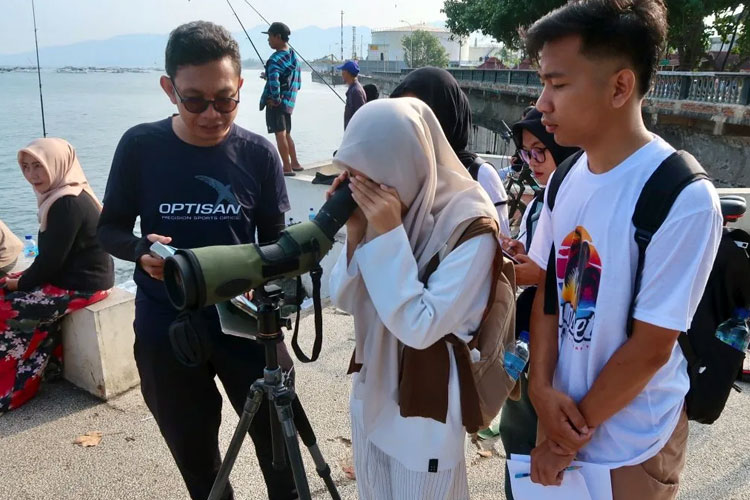 Arsip - Sejumlah warga menggunakan teropong untuk melihat burung-burung migran yang sedang mencari pakan di tengah laut Pantai Ampenan, Kota Mataram, Nusa Tenggara Barat, Minggu (22/6/2025). (FOTO: ANTARA/Sugiharto Purnama)