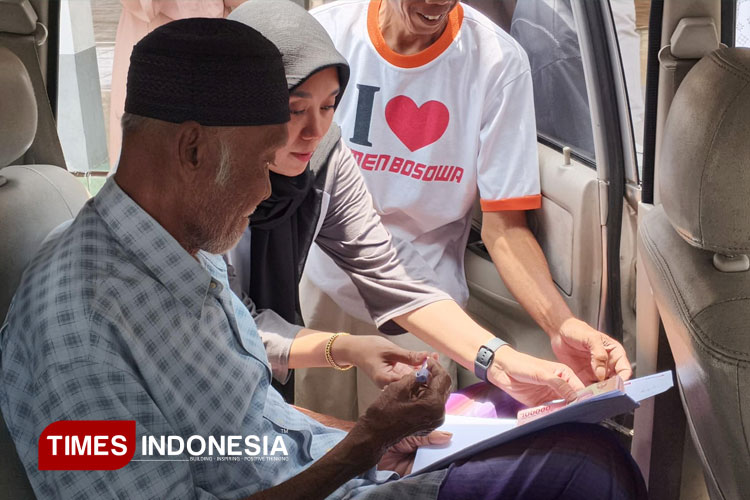 Lurah Kranjingan, Ica Ghea Hernawati, saat menyerahkan insentif guru ngaji terhadap kiyai Sya'i di mobil penjemputan. (FOTO: M. Abdul Basid / TIMES Indonesia)